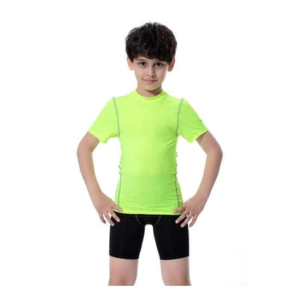 Young boy in a bright green sport t-shirt and black shorts posing confidently against a white background.